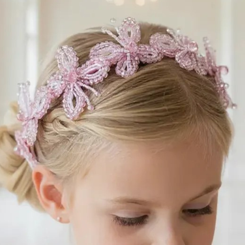 Model wearing handmade girls crystal butterfly headband, hand beaded with pink crystals, perfect for childrens special occasions.