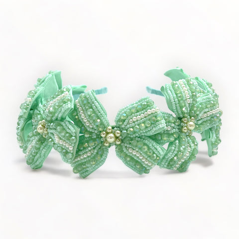 Buy the ultimate in luxury hair accessories for children.  An entirely handcrafted bow headband in mint green.  Hand stitched with hundreds of mint green crystals and. pearls.  Perfect for kids special occasionwear.