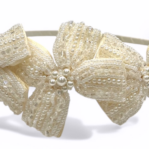 A uniquely bespoke flower girl ivory headband that has been hand stitched with pearls and crystals.  This childs bow headband makes a fabulous bridal or special occasion headpiece.