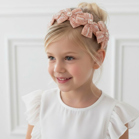 Designer bow headband for girls in pastel apricot, hand beaded with soft blush and apricot beads and pearls.