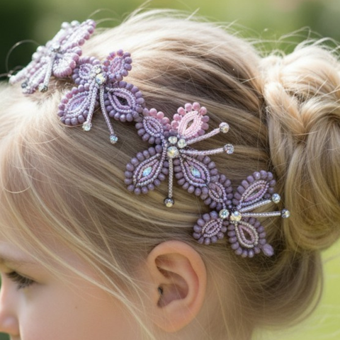 Close-up of a child's head with a handmade designer butterfly headband in lilac with diamante setting in their blonde hair.