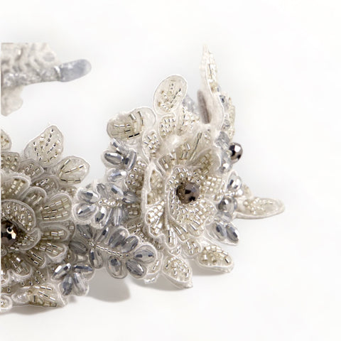 Close-up of the Hadraniel Crystal Flower Headband showcasing intricate white lace flowers embellished with silver crystals and pearls