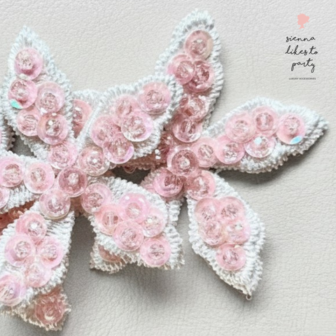 Close up of pastel pink girls hand beaded flower hair clip.  Set on three embroidered flowers.  Handmade by Sienna Likes to Party - Bespoke Hair accessories for children